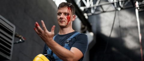 blutender Mann mit Schraube im Kopf