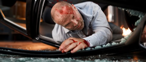 Mann kriecht aus verunglücktem Fahrzeug aus